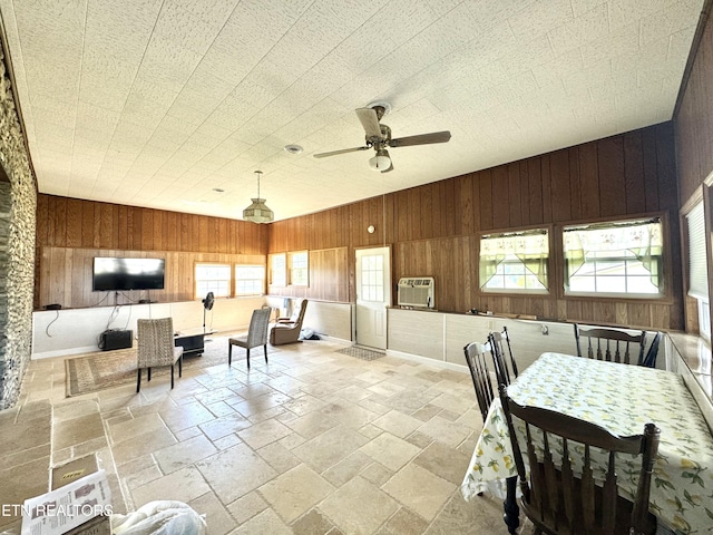 dining area with stone tile floors and wooden walls