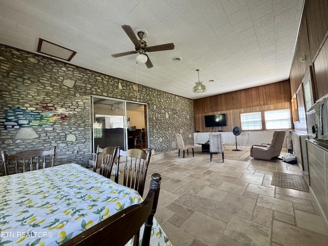 dining room featuring stone tile floors and a ceiling fan