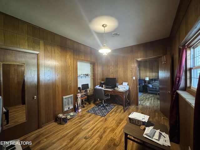 office space with wooden walls, wood finished floors, and visible vents