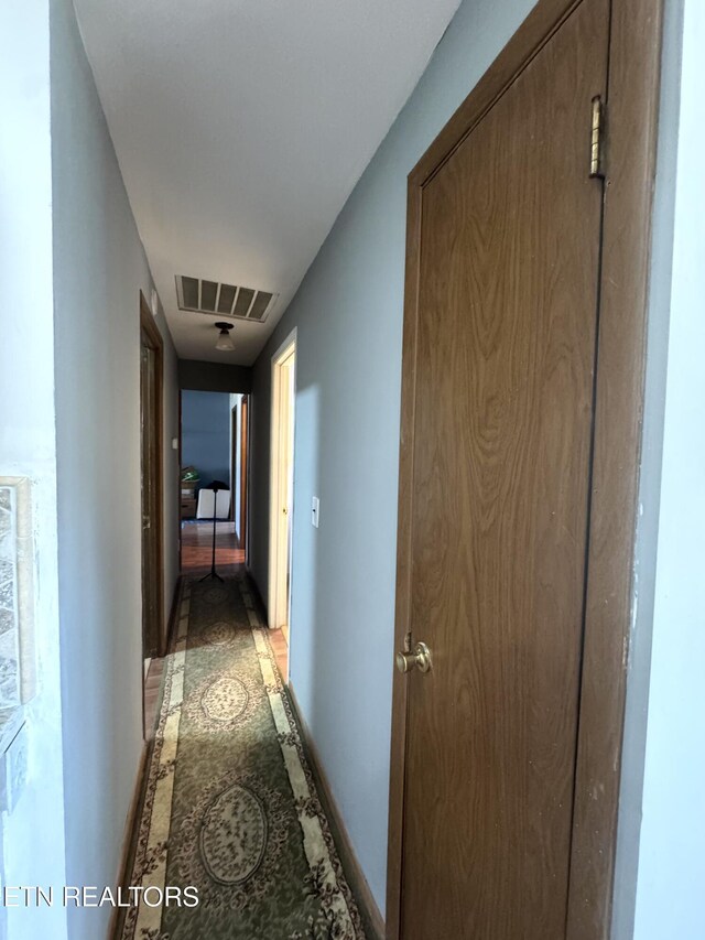 hallway featuring visible vents and baseboards