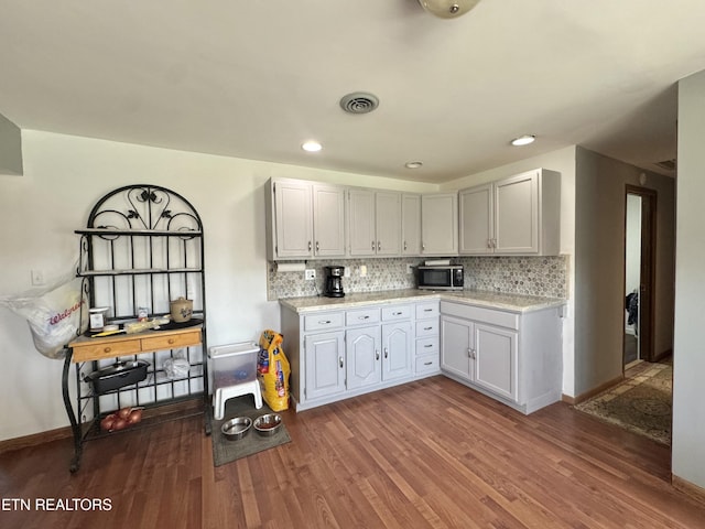 kitchen with decorative backsplash, visible vents, wood finished floors, baseboards, and recessed lighting