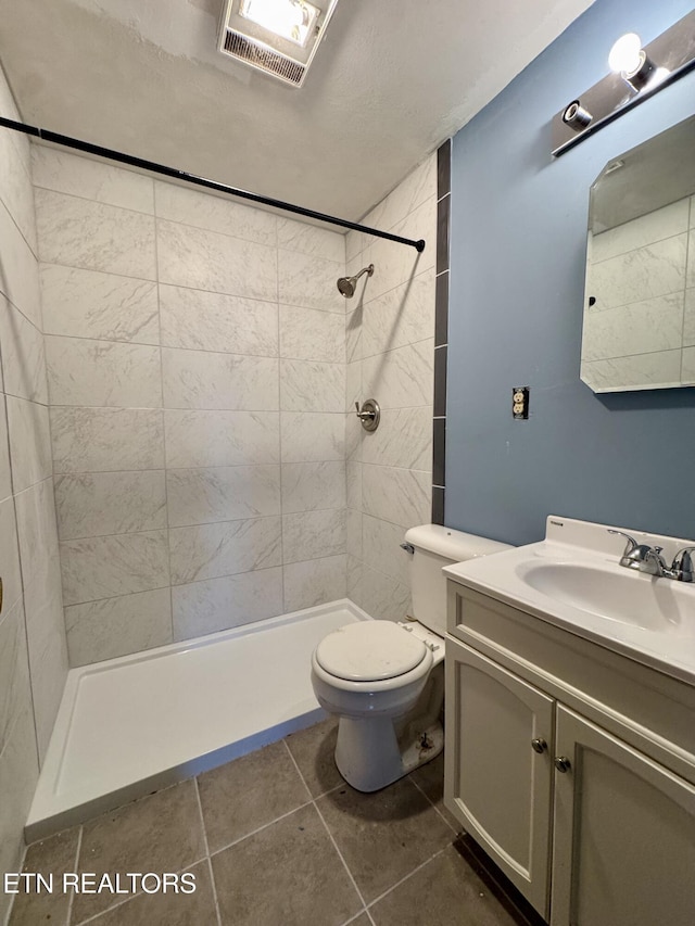bathroom featuring tile patterned floors, toilet, tiled shower, and visible vents