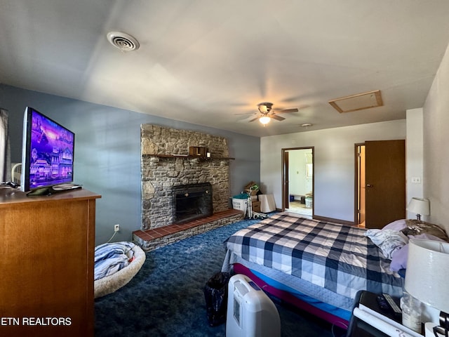 bedroom featuring visible vents, a fireplace, attic access, a ceiling fan, and carpet