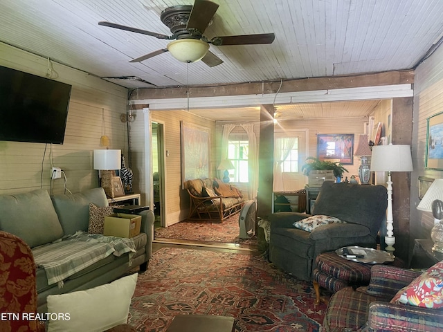 living area featuring ceiling fan, wood walls, and wood ceiling