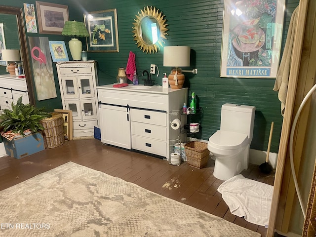 bathroom with toilet, wood-type flooring, and vanity