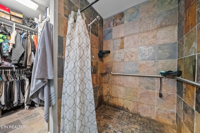 full bathroom with a walk in closet and a stall shower