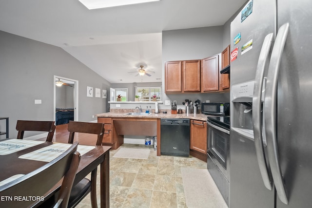 kitchen with a peninsula, lofted ceiling, brown cabinets, a sink, and black appliances