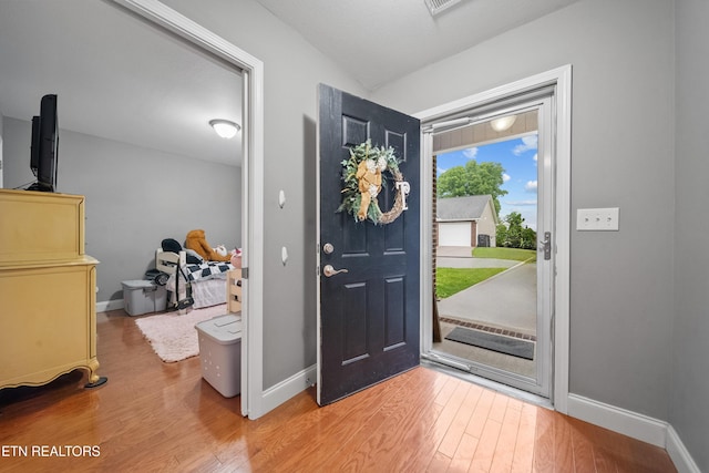 foyer featuring baseboards and wood finished floors