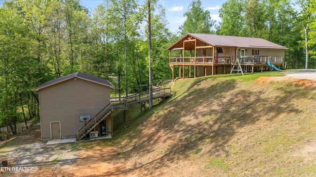 rear view of house featuring stairs and a deck