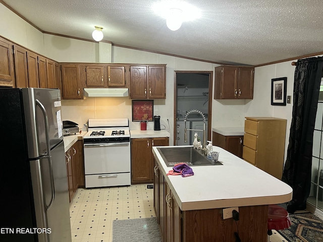 kitchen featuring freestanding refrigerator, under cabinet range hood, white range with gas cooktop, a textured ceiling, and lofted ceiling