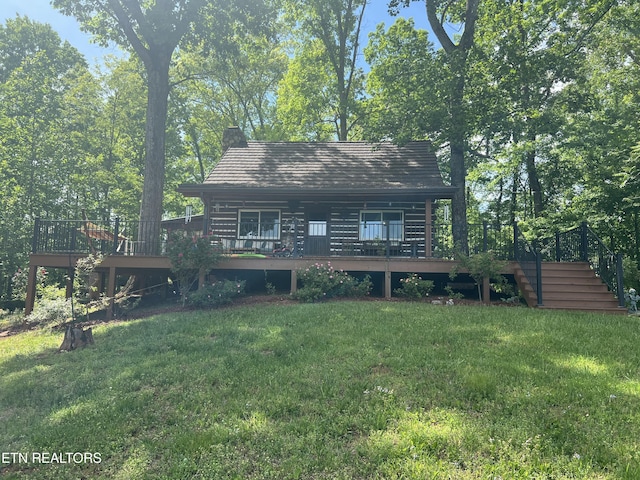 back of house featuring a chimney, stairway, a deck, and a lawn