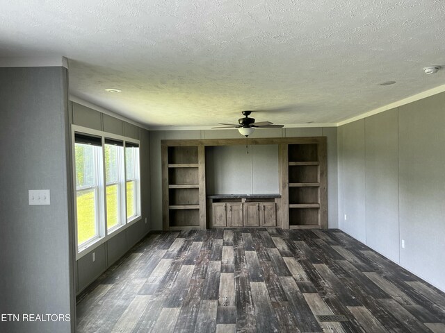unfurnished living room with a textured ceiling, crown molding, ceiling fan, wood finished floors, and built in features