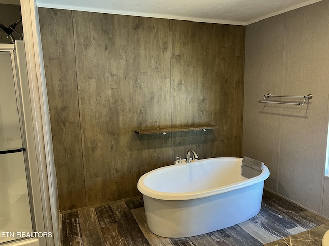 bathroom with a freestanding tub and wood finished floors