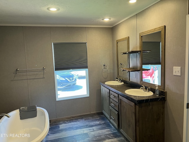 bathroom with ornamental molding, double vanity, a sink, and wood finished floors