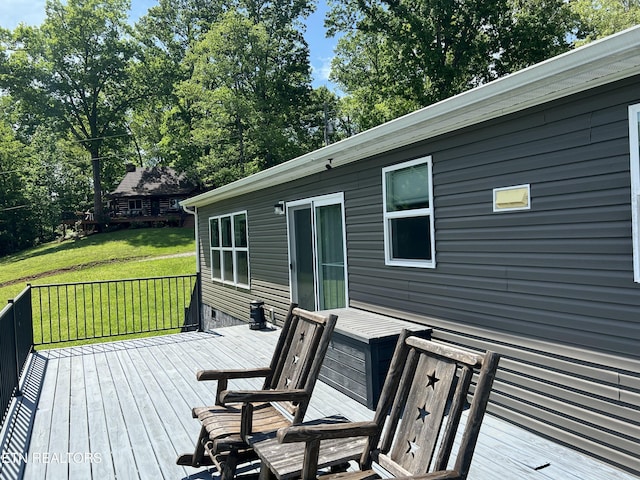 wooden deck featuring a lawn
