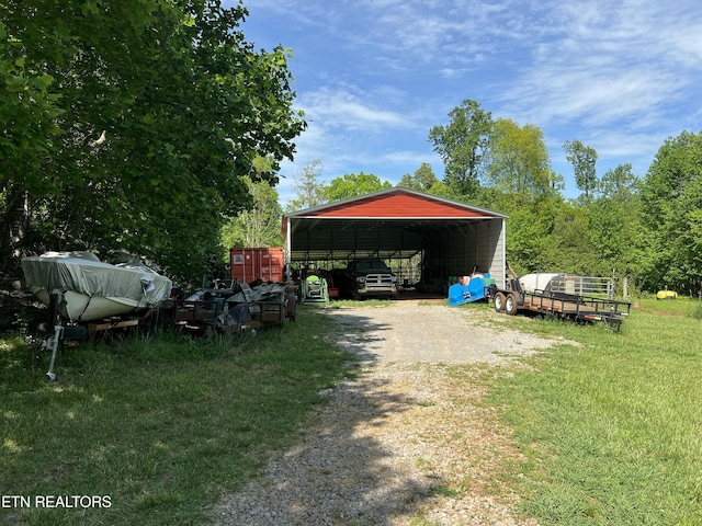 view of car parking with a detached carport and dirt driveway