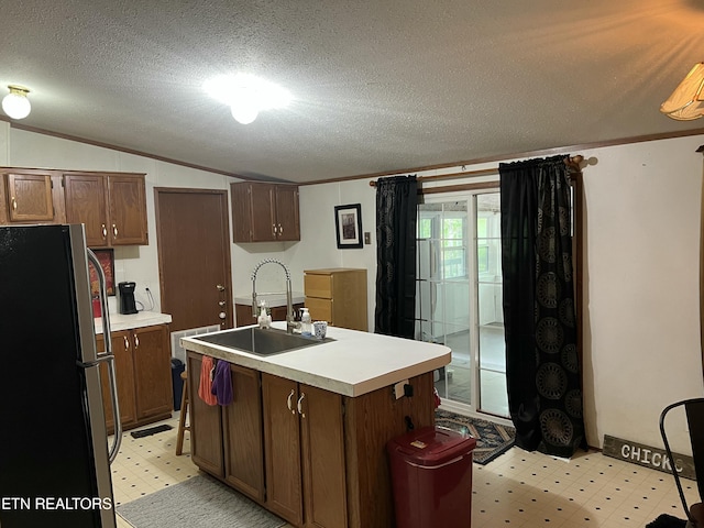 kitchen with lofted ceiling, a sink, light countertops, freestanding refrigerator, and light floors