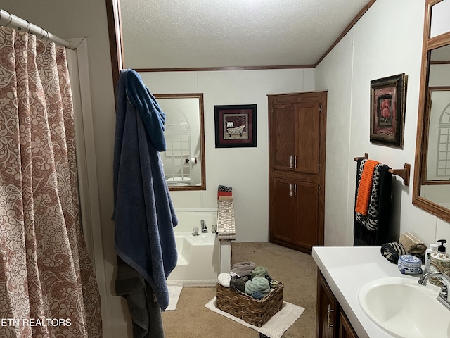 bathroom with a textured ceiling, vanity, crown molding, and a bath