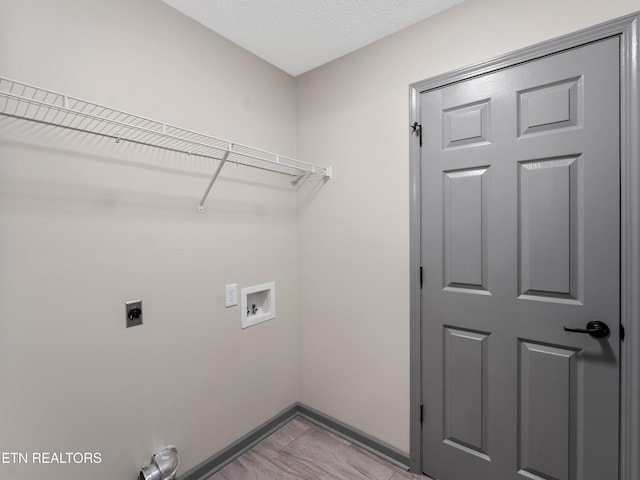 laundry area with light tile patterned flooring, laundry area, washer hookup, baseboards, and hookup for an electric dryer