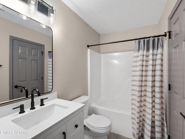 full bath featuring vanity, toilet, a textured ceiling, shower / bathtub combination with curtain, and visible vents