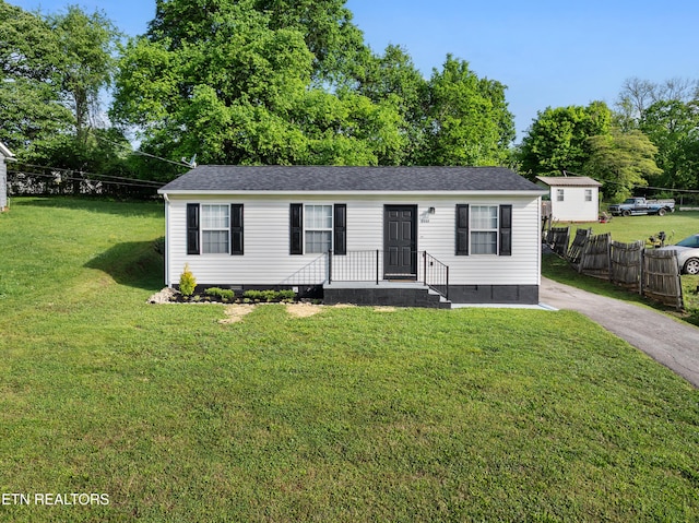 manufactured / mobile home featuring crawl space, fence, a shingled roof, and a front lawn