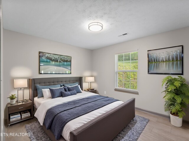 bedroom featuring baseboards and visible vents