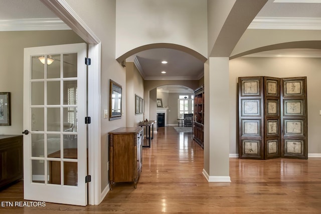 301 Coyatee Shores Trce, Loudon, TN 37774 - foyer entrance featuring arched walkways, wood finished floors, a glass covered fireplace, ornamental molding, and baseboards