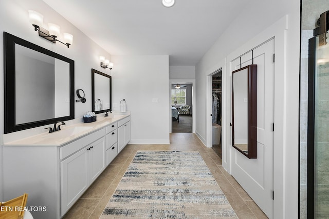 bathroom with ceiling fan, tile patterned flooring, double vanity, and a sink