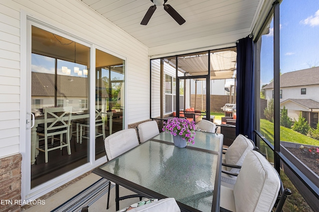 sunroom / solarium with ceiling fan and outdoor dining area