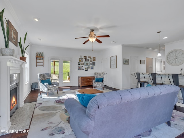 living area featuring ceiling fan, crown molding, wood finished floors, recessed lighting, and a premium fireplace