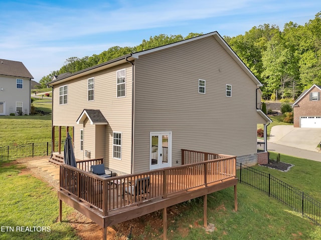 rear view of property with a lawn, a fenced backyard, and a deck
