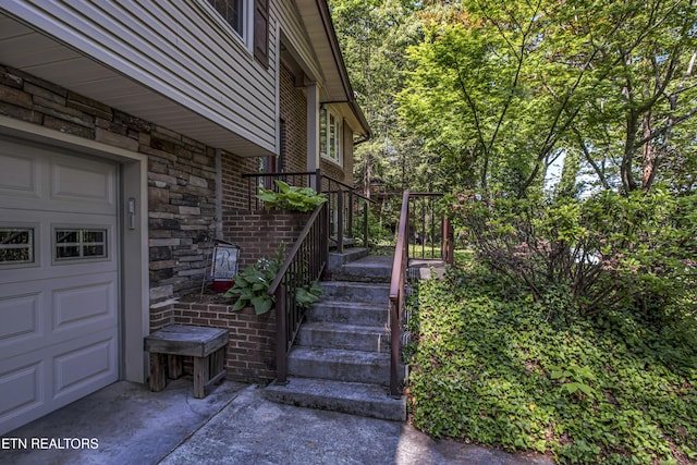 view of home's exterior featuring a garage, stone siding, and brick siding