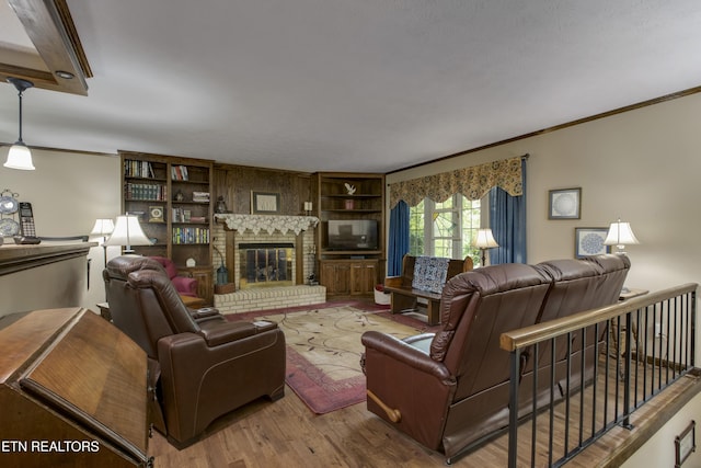 living room featuring ornamental molding, a brick fireplace, and wood finished floors