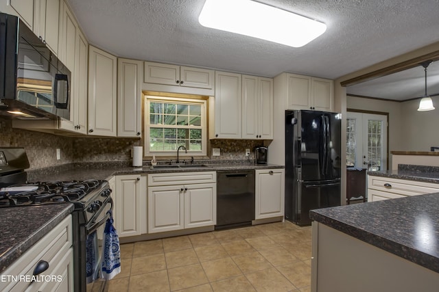 kitchen with decorative backsplash, dark countertops, a sink, light tile patterned floors, and black appliances