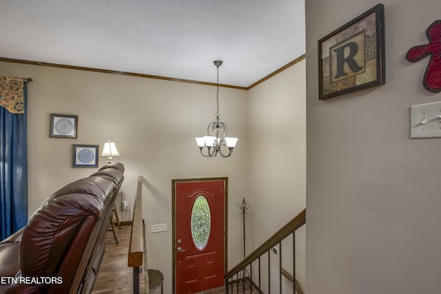 entrance foyer featuring crown molding, wood finished floors, and a chandelier