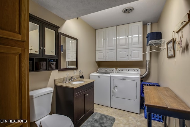 clothes washing area featuring a sink, visible vents, laundry area, and washer and clothes dryer
