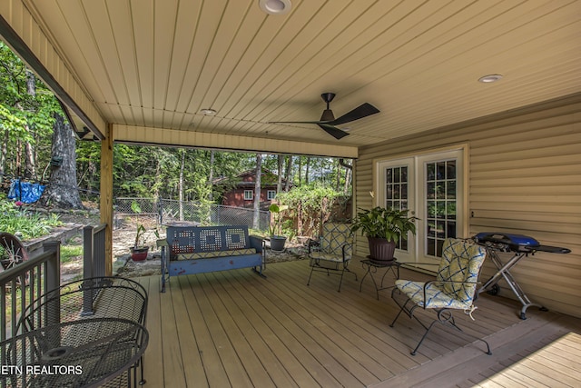 wooden terrace with fence, a ceiling fan, and french doors