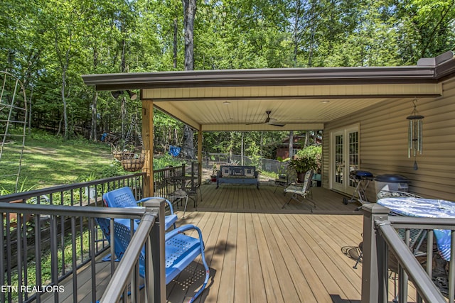 wooden deck with outdoor dining area, ceiling fan, and french doors
