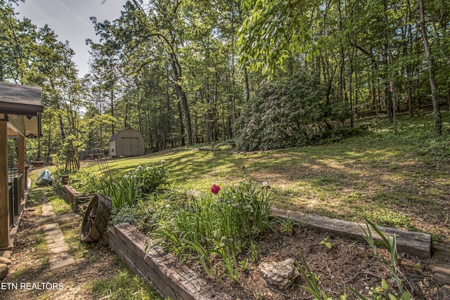 view of yard with an outbuilding, fence, and a storage shed