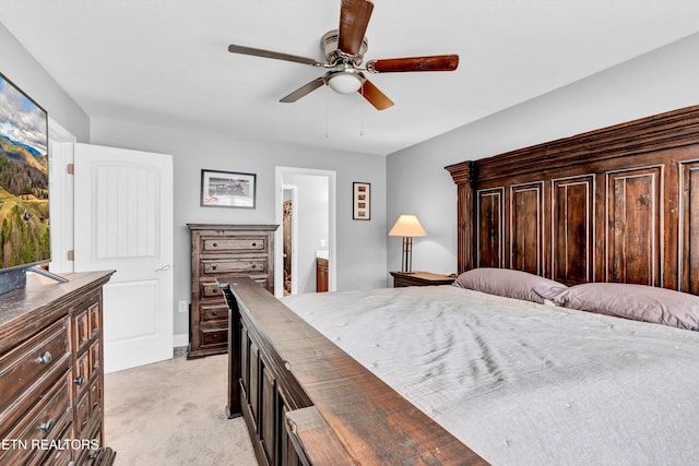 bedroom with ceiling fan, light colored carpet, and ensuite bathroom