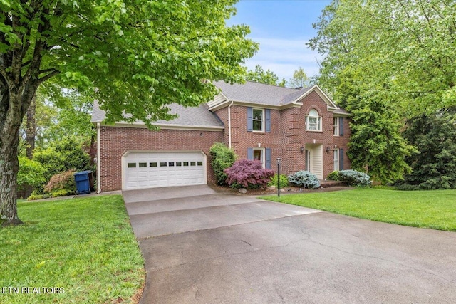 colonial inspired home with driveway, roof with shingles, a front lawn, and brick siding