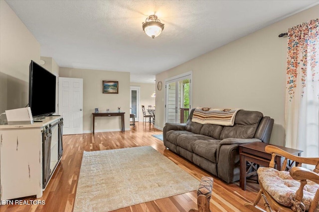 living room featuring light wood-type flooring and baseboards