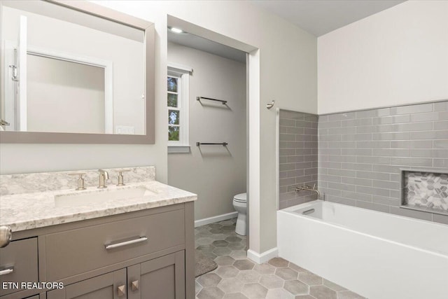 bathroom with tile patterned flooring, toilet, a bath, vanity, and baseboards