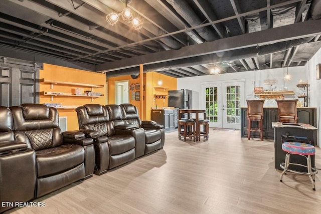 home theater with bar area, visible vents, wood finished floors, and french doors