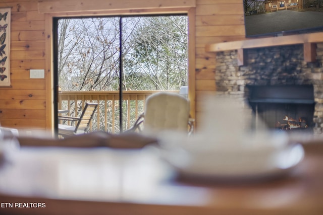 interior space with wooden walls, a lit fireplace, and a wealth of natural light