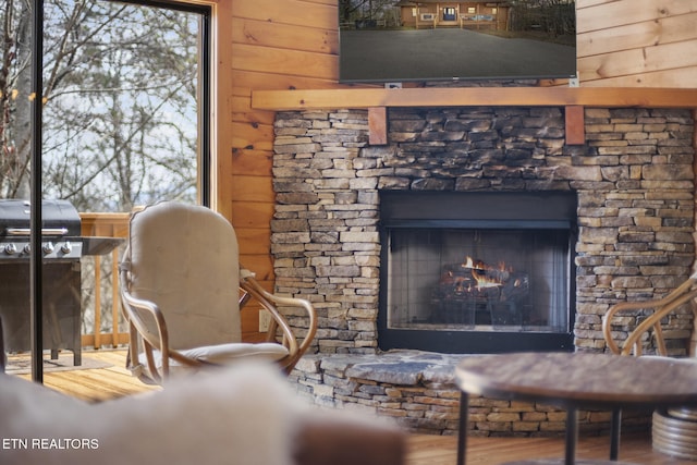 interior space featuring wood finished floors, wooden walls, and a fireplace