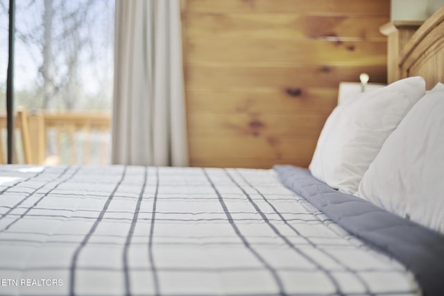 bedroom featuring wooden walls