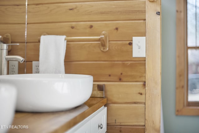 bathroom featuring vanity and wood walls