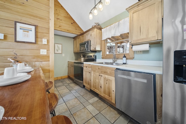 kitchen with appliances with stainless steel finishes, a sink, light brown cabinets, light countertops, and lofted ceiling
