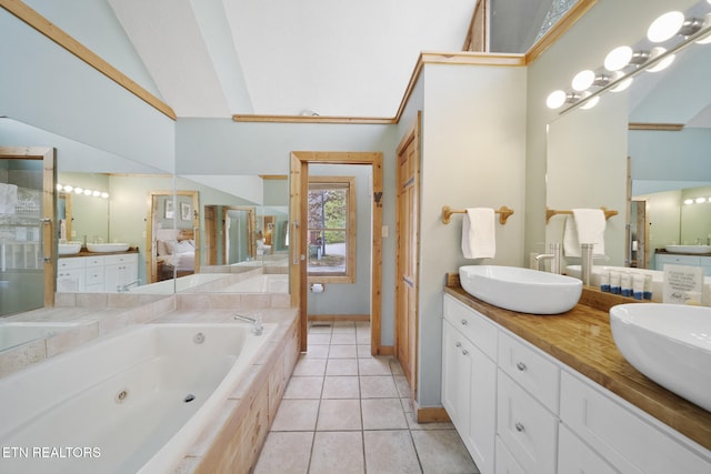 full bath featuring a sink, double vanity, a whirlpool tub, baseboards, and lofted ceiling